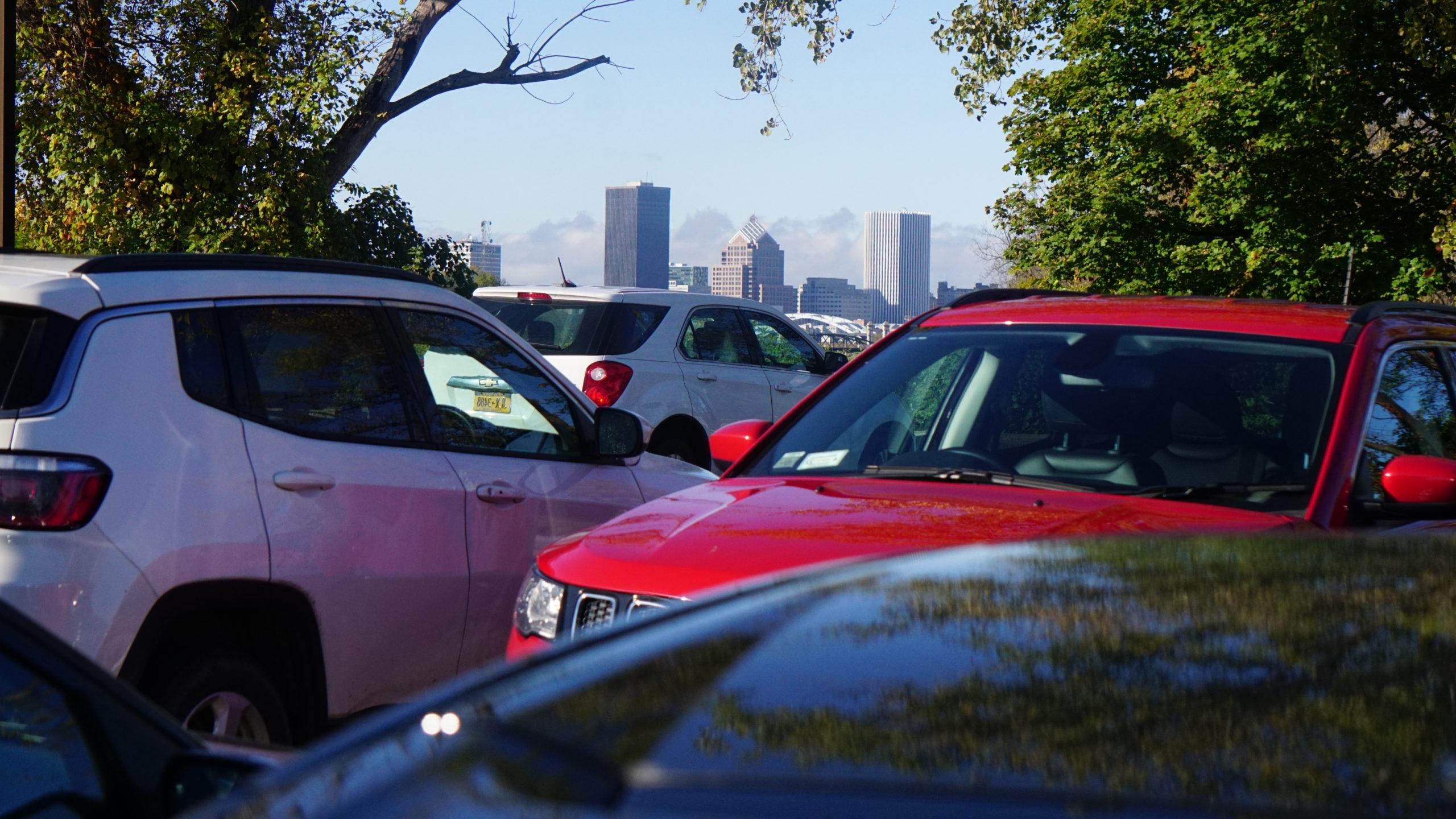 红色和白色的车辆停在停车场，背景是纽约澳门威尼斯人网上赌场市的天际线